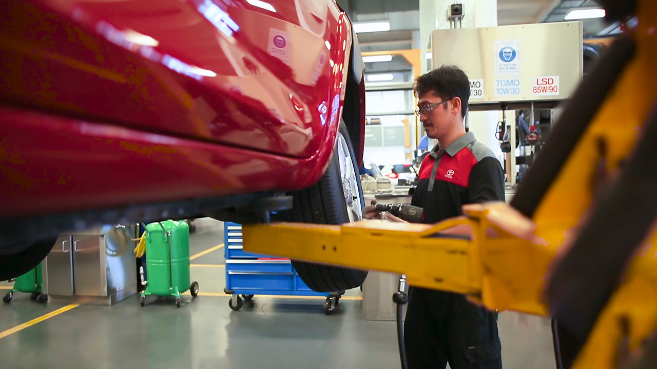 Mechanic apprentice working on a car at Sci-Fleet Motors